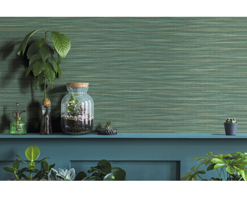 Dekorativa krukväxter och en grön strukturtapet på en hylla