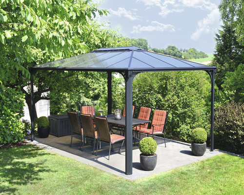 Paviljong med bord och stolar i trädgården.