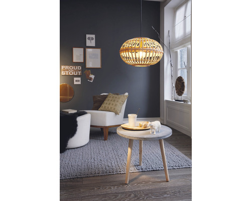 Vardagsrum med fåtölj, sidobord och hänglampa av rotting