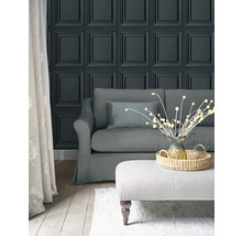 Vardagsrum med paneltapet, soffa och pall
