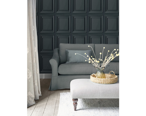 Vardagsrum med paneltapet, soffa och pall