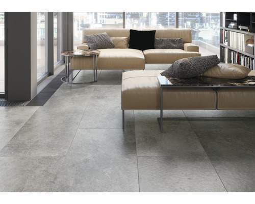 Ljust vardagsrum med klinkergolv, soffa och bokhylla