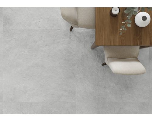 Ljust rum med plattor i stenlook, bord och stolar.