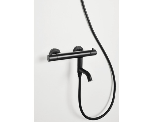Svart duschblandare med slang monterad på väggen