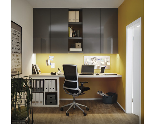 Arbetsrum med skrivbord, kontorsstol, hyllor och kontorsmaterial