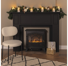 Dekorativ interiör med elektrisk eldstad, stol, matta och juldekoration