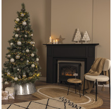 Juldekorerat vardagsrum med julgran, öppen spis och matta