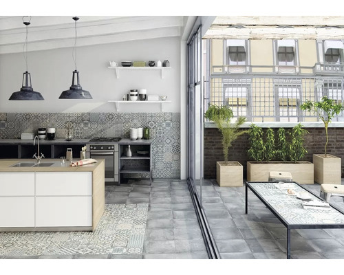 Ljust kök med köksö, klinkergolv och tillgång till en terrass med blomlådor.