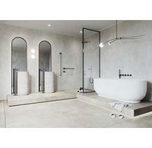 Modernt badrum med fristående badkar, handfat och dusch bakom glas