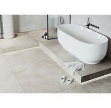 Badrum med fristående badkar, klinkergolv och tvättställ