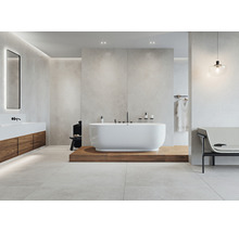 Ljust badrum med fristående badkar, tvättställ och sittbänk