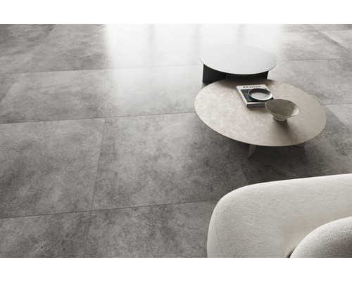 Ljust vardagsrum med golvplattor i betonglook, soffa och soffbord