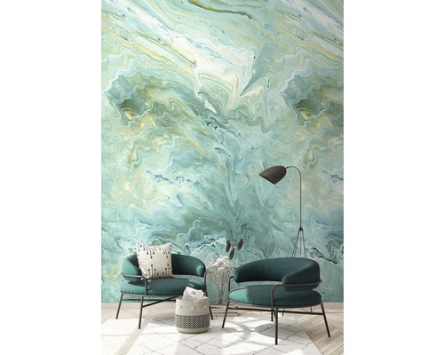 Vardagsrum med två fåtöljer och en väggbeklädnad i marmordesign