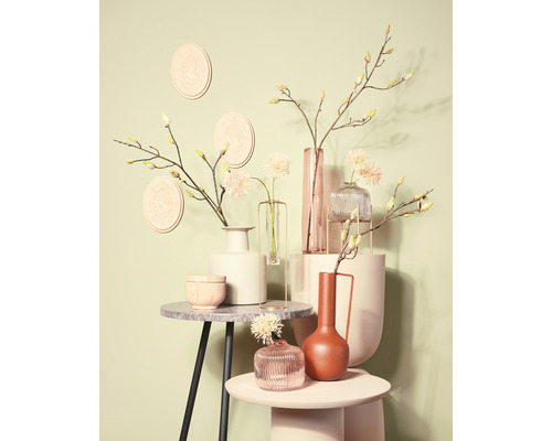 Arrangemang av olika vaser med dekorationer på bord