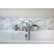 Badrum med badkar, armatur, kakel i marmorlook och dekoration