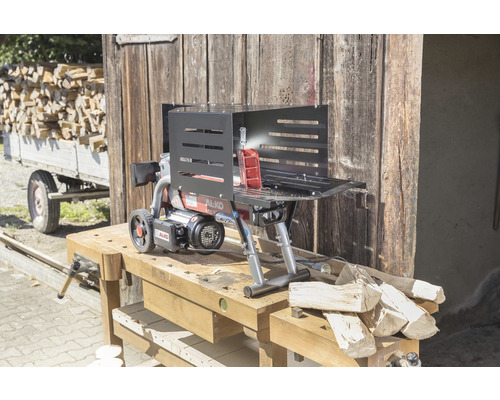 Vedklyv på en arbetsbänk framför en trävägg