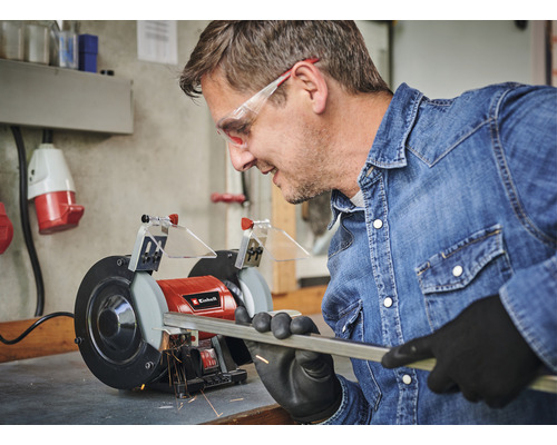 Man slipar metallstång med en Einhell dubbelslipmaskin