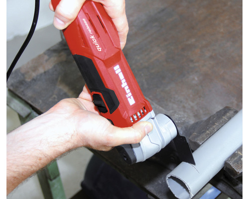 En man skär ett rör med ett multifunktionsverktyg.