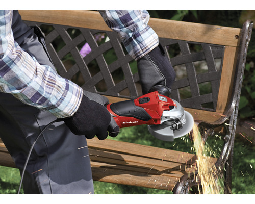 En person använder en Einhell vinkelslip för att slipa en trädgårdsbänk.
