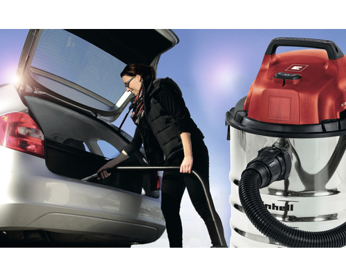 En kvinna rengör bagageutrymmet på en bil med en Einhell våt- och torrdammsugare.