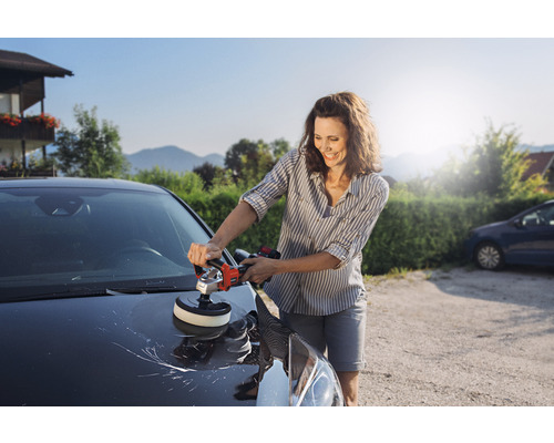 Kvinna polerar bil med polermaskin