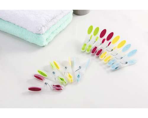 Flerfärgade klädnypor bredvid handdukar