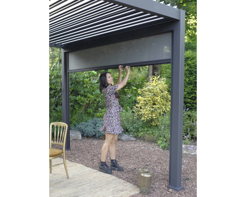 Kvinna som använder en pergola med insynsskydd i trädgården.