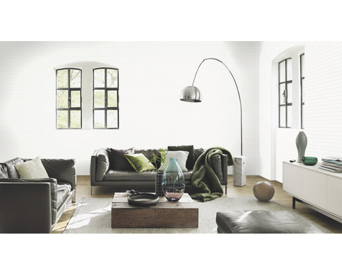 Ljust vardagsrum med lädersoffa och mönstrad tapet i stenimitation