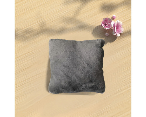 Grå kudde på ett träbord med blommor