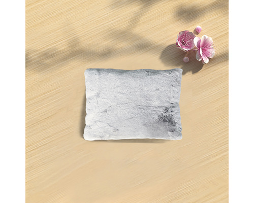 Dekorativ kudde med pälsstruktur på ett bord