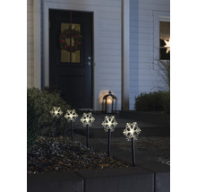 Dekorativa snöflingljus på en husgård med en krans på dörren