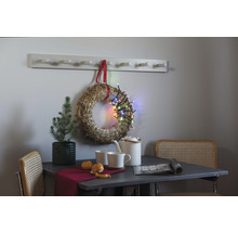 Miljöbild med bord, stolar, halmkrans med ljusslinga, växt, porslin och klädhängare