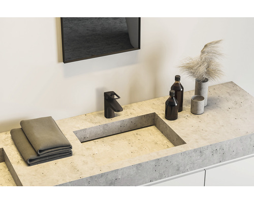 Badrum handfat med blandare, handdukar, flaskor och dekoration