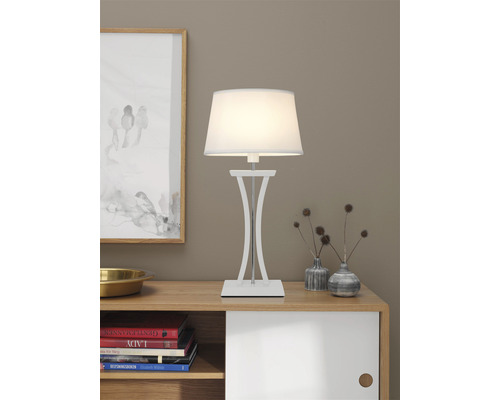 Bordslampa med lampskärm på ett träskåp