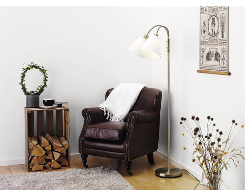 Vardagsrumsscen med brun fåtölj, golvlampa och dekorationer