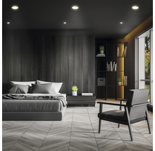 Sovrum med säng, fåtölj och bokhylla i mörk design