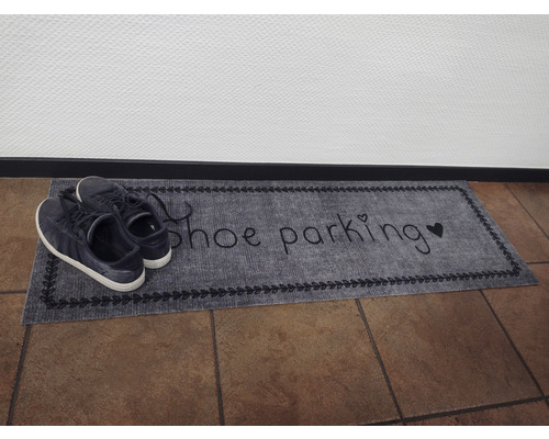 Dörrmatta med inskriptionen skoparkering och skor på den