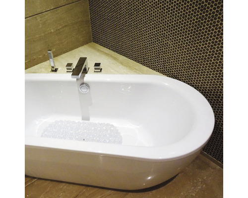 Fristående badkar med blandare i ett badrum med mosaikplattor