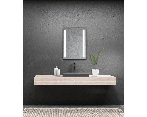 Modernt badrum med belyst spegel, handfat och underskåp