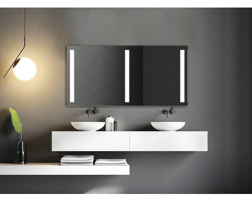 Badrum med handfat, spegel med belysning och handdukar