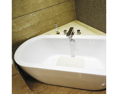 Fristående badkar med blandare i ett badrum med kakel