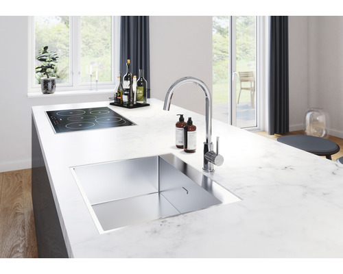 Köksö med diskho, blandare och häll i en ljus, modern köksdesign.