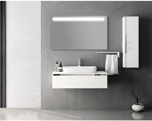 Modernt badrum med vitt tvättställ, belyst spegel och högskåp.