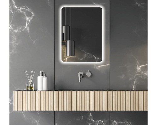 Badrum med belyst spegel, tvättställsskåp och dekorativa element