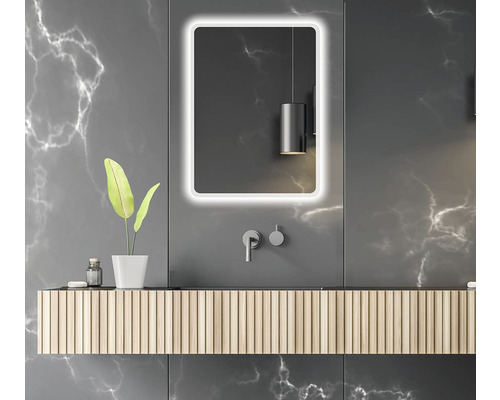 Modernt badrum med belyst spegel, tvättställ och grå marmorvägg