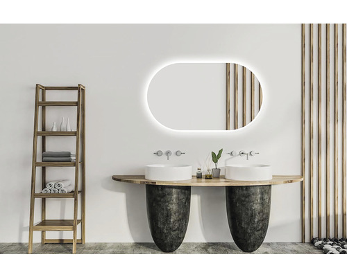 Badrum med dubbla handfat, belyst spegel, trähylla och dekorativ väggbeklädnad