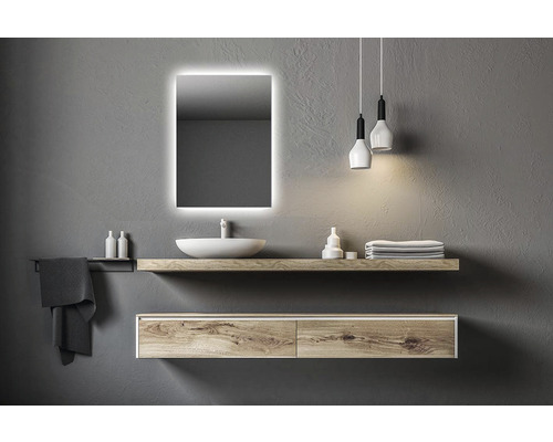 Modernt badrum med belyst spegel, handfat, hylla och hänglampor