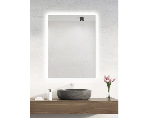 Badrum med upplyst spegel, handfat och bukett