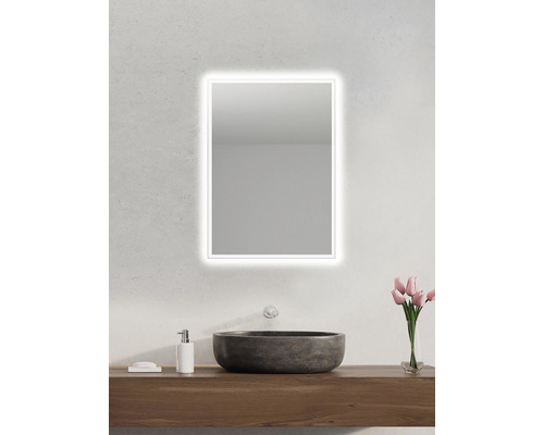 Badrum med belyst spegel, tvättställ och tvättställsskåp