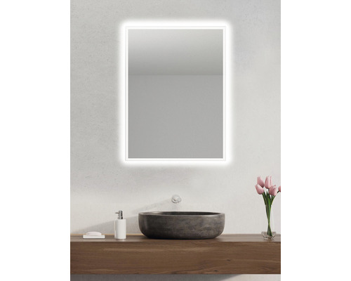 Modernt badrum med belyst spegel ovanför en bänkskiva